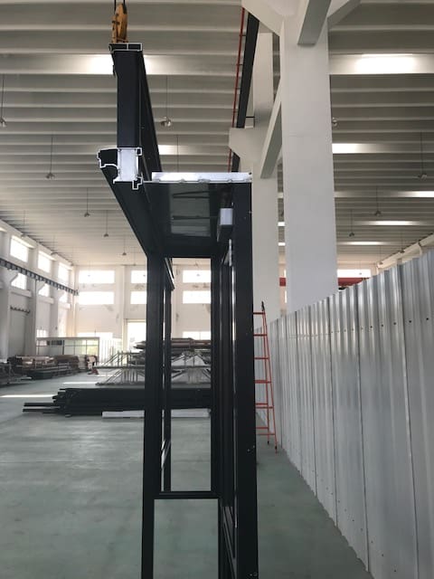 A black lift in an industrial building with no one inside.