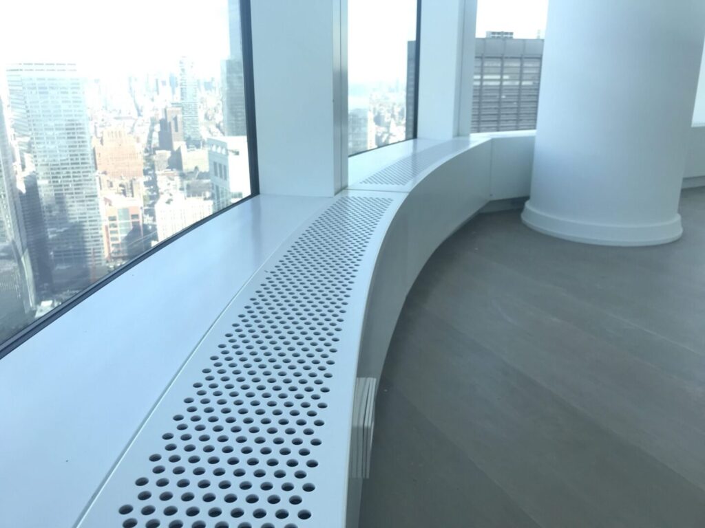 A white bench in front of a window.