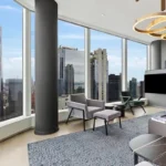 A living room with large windows and a view of the city.