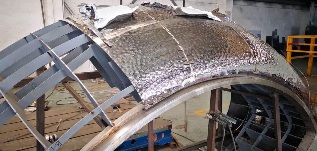 A metal structure being constructed with a sheet of aluminum foil.