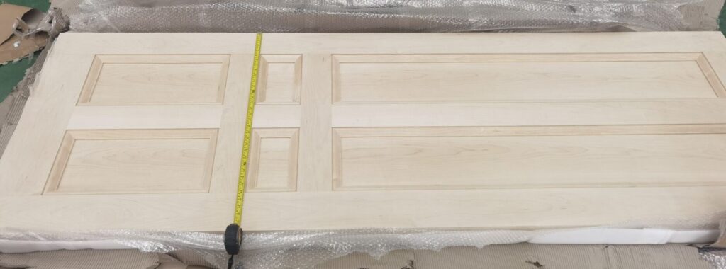 A wooden door with a tape measure on it.