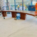 Large wooden desk with multiple drawers in an office space.