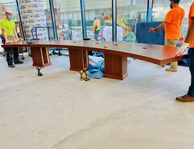 Large wooden desk with multiple drawers in an office space.