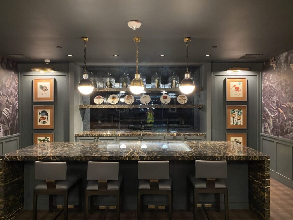 A bar with many chairs and lights above it