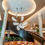 A large lobby with a spiral staircase and a round couch.