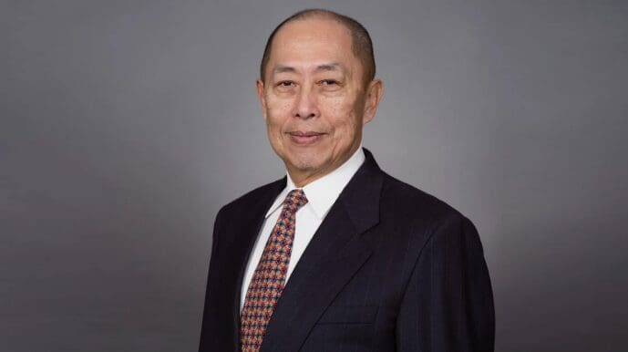 A man in suit and tie standing next to a wall.