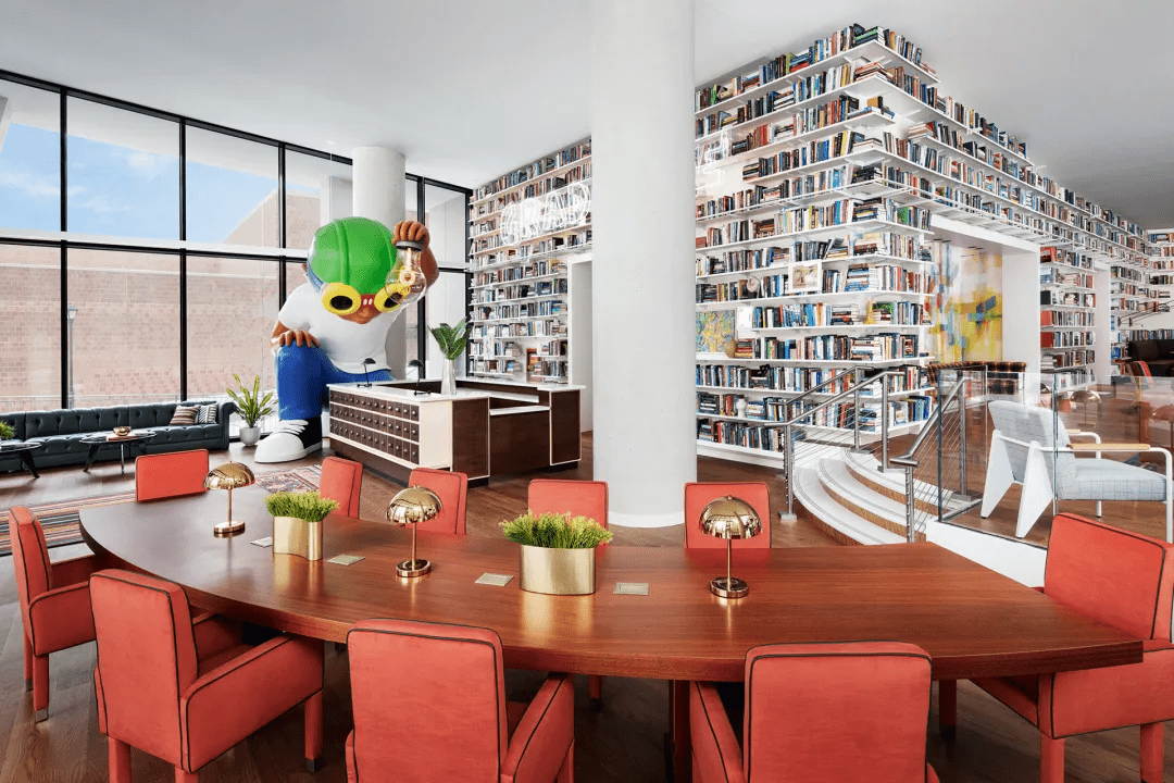 Modern library with large bookshelves and a communal wooden table.