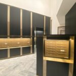 A room with black and gold walls, a large wall of cabinets.