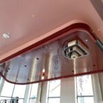 Modern ceiling design with hanging lights and a projector.