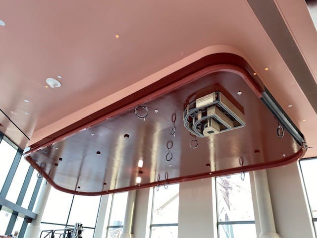 Modern ceiling design with hanging lights and a projector.