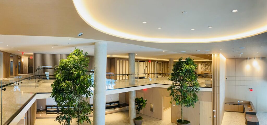 A large lobby with many trees and plants.