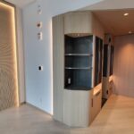 Modern living room corner with built-in shelves and soft lighting.