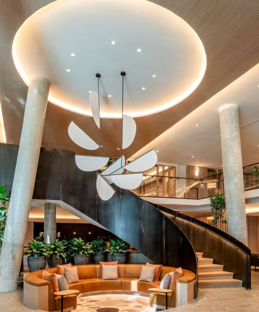 A large lobby with a spiral staircase and a round couch.