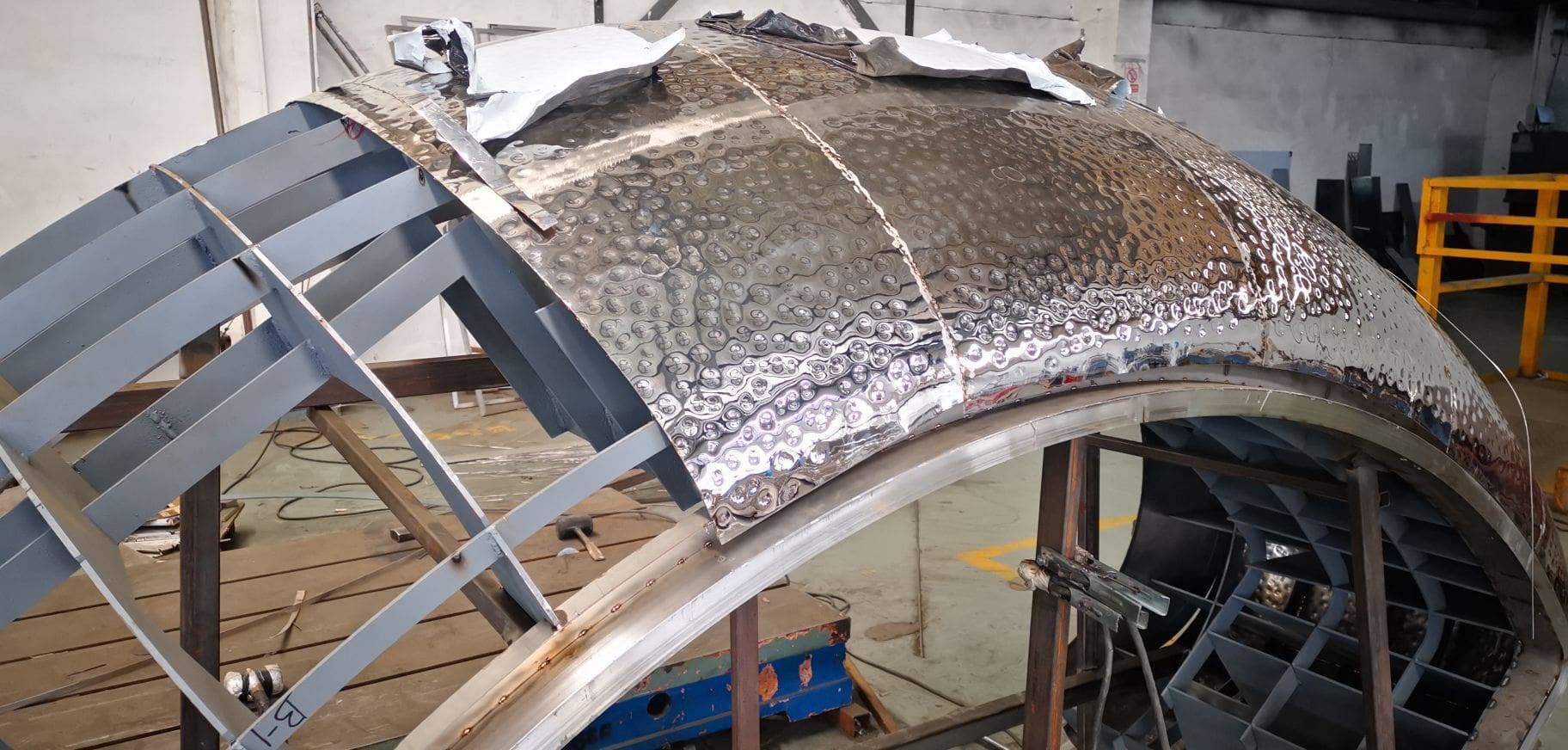 A metal structure being constructed with a sheet of aluminum foil.