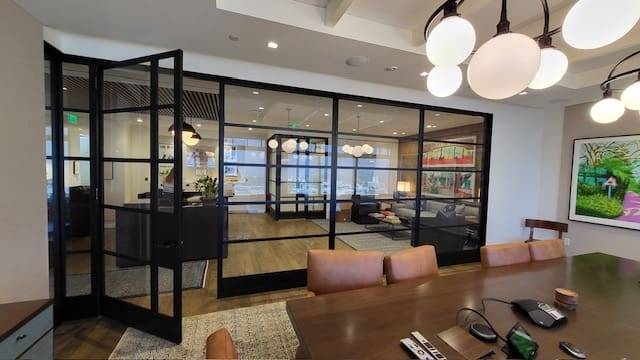 A room with glass walls and wooden table.